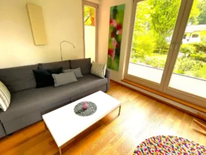 wohnzimmer-schlafsofa-gartenblick-garten-apartment-seeshaupt-urlaub-oberbayern